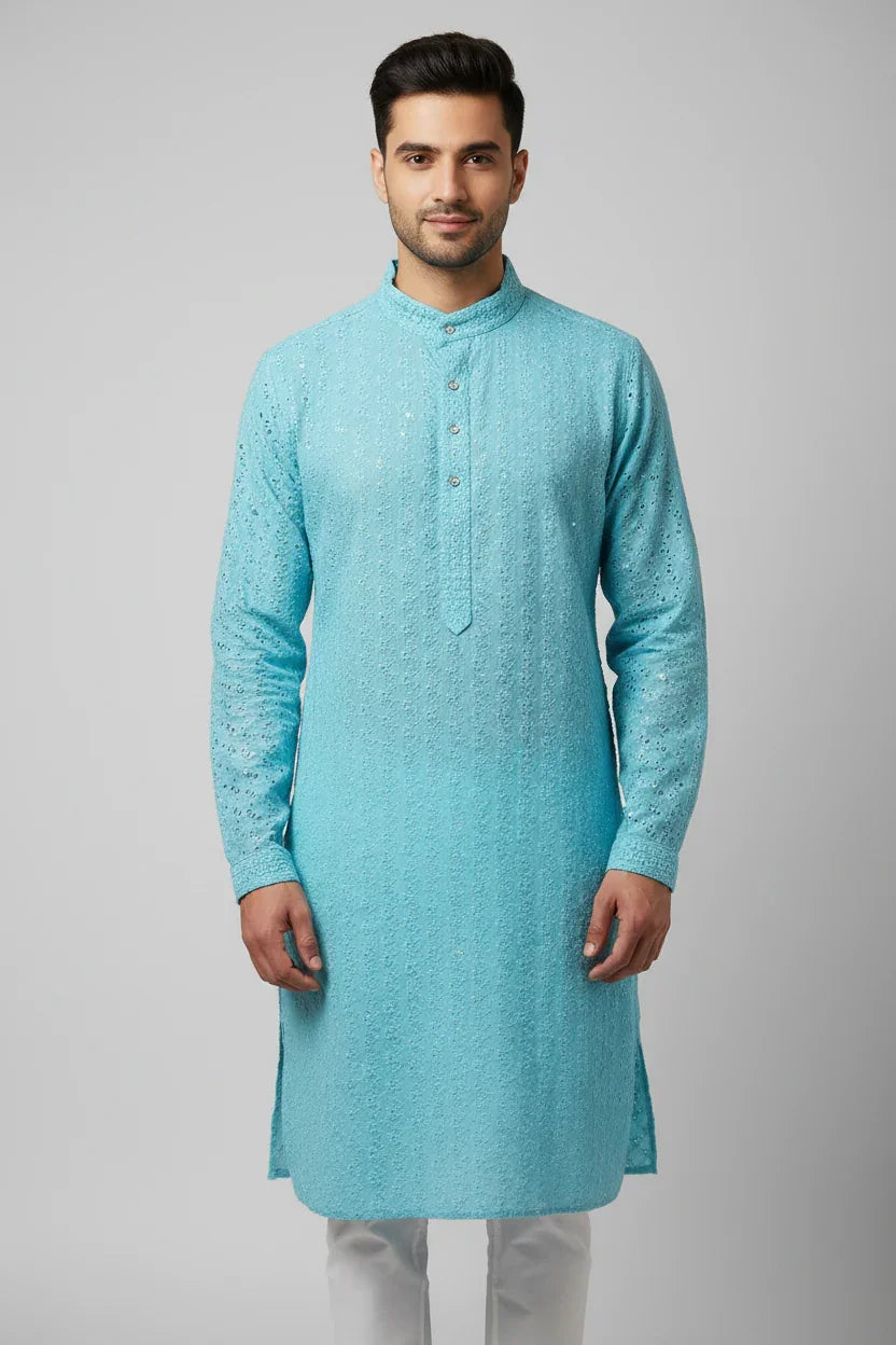 Man wearing sky blue embroidered Indian ethnic kurta with white churidar against gray background
