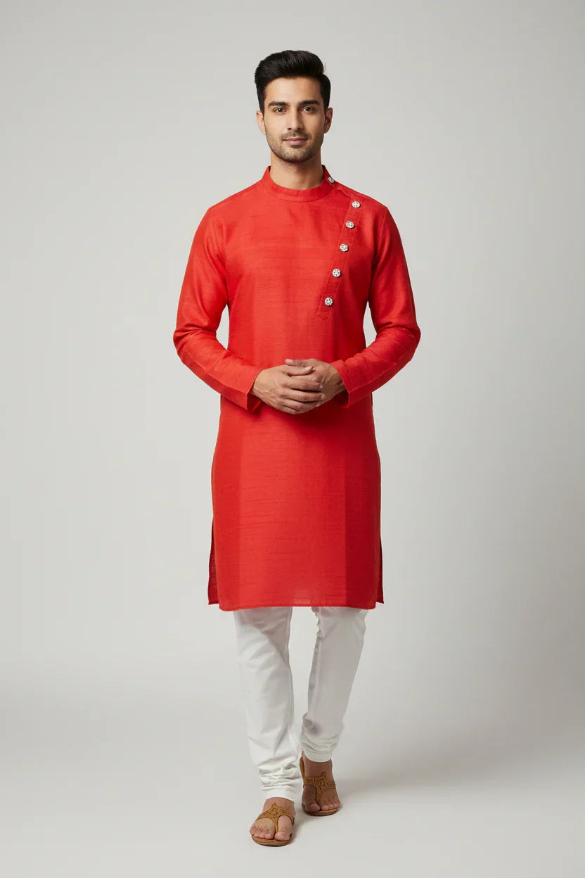 Man wearing red Indian ethnic kurta with decorative buttons, white churidar pants, and brown sandals