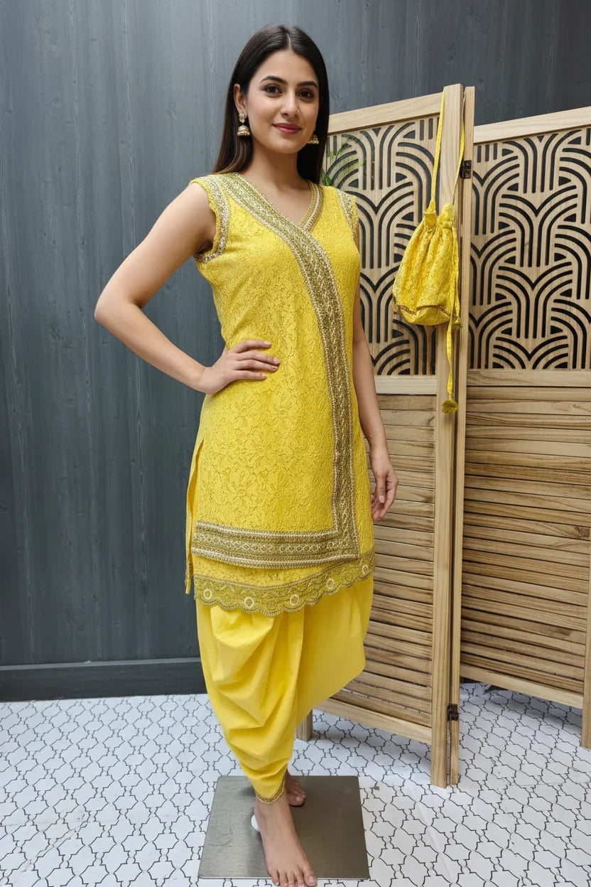 Woman in sleeveless yellow embroidered Indian ethnic kurta with matching dupatta bag and dhoti pants, standing indoors