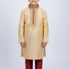 Young boy wearing beige embroidered kurta with maroon churidar and traditional shoes, Indian ethnic wear